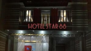 The entrance to HOTEL STAR 88 with a glass facade and a red sign. - Hotel Star 88 (Sleman)
