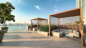 Terraço no telhado com área de estar, plantas em vasos e vista do horizonte da cidade.