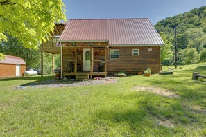 A wooden cabin with a porch, a small deck, and a metal roof. - Family Cabin! Close to Greenbrier River & Snowshoe (Cass)