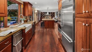 Una cocina amplia con armarios de madera, electrodomésticos de acero inoxidable y una isla central.