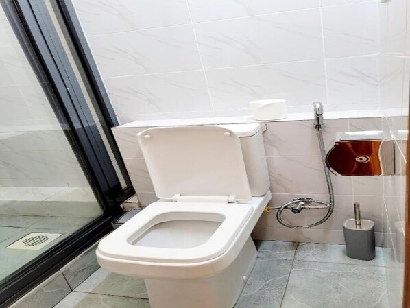 A bathroom with a toilet, a bidet, and a shower. - The United Kenya Club (Nairobi)