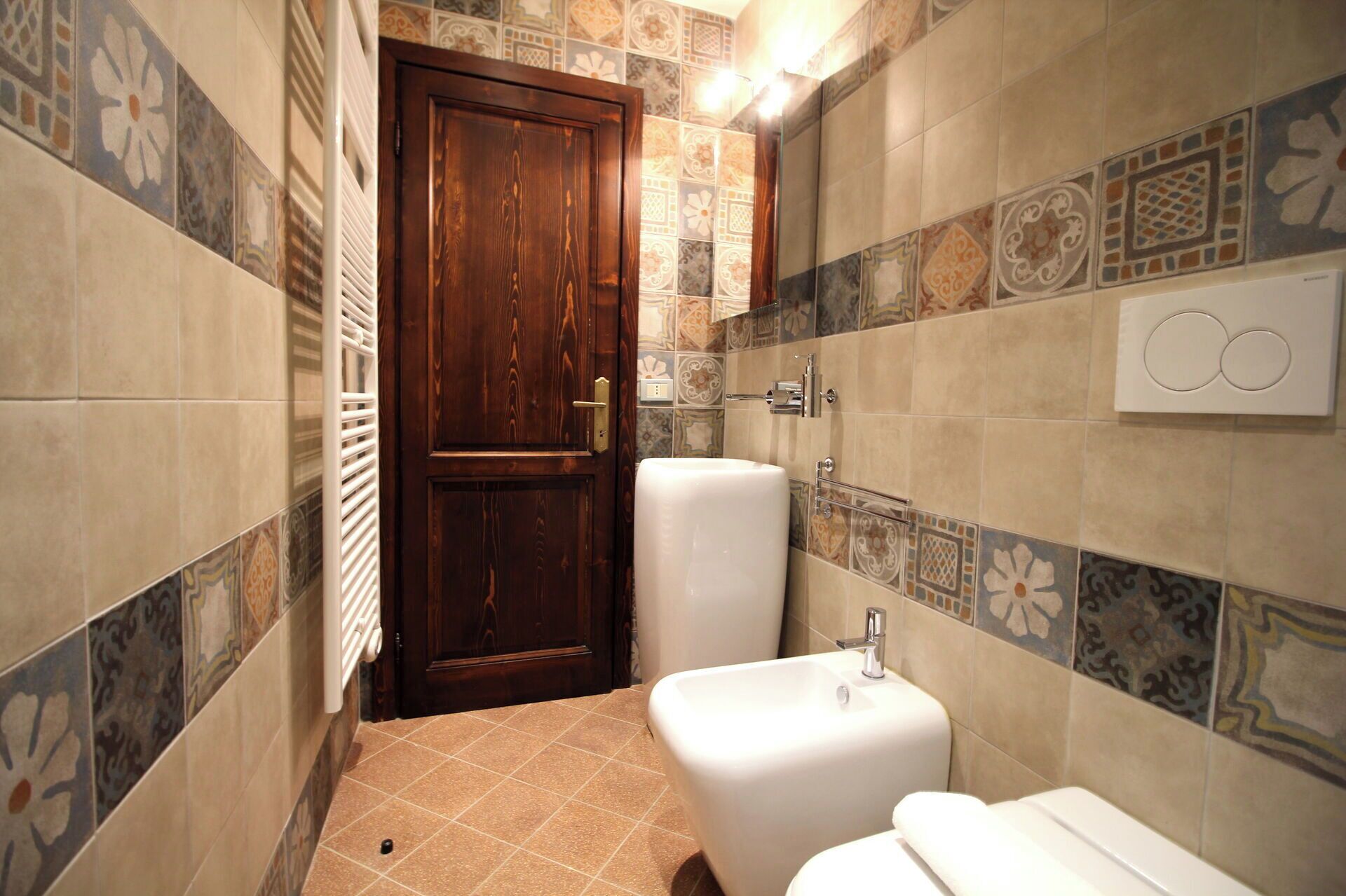 A bathroom with a wooden door, a white sink, and a toilet.