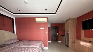 A hotel room with a bed, a TV, a kitchenette, and a bathroom. - Modern Studio With Balcony and Pool - Pratumnak Hill (Pattaya)