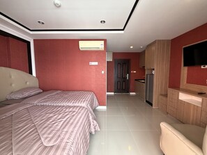 A hotel room with a bed, a TV, a kitchenette, and a bathroom. - Modern Studio With Balcony and Pool - Pratumnak Hill (Pattaya)