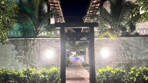 A pathway leading to a gated entrance with a sign above it. - House in Búzios (Geribá) a few meters from the beach. (Armação dos Búzios)