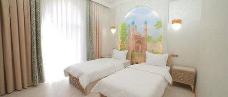 A hotel room with two beds, a large window with curtains, a wall mural, and a nightstand.