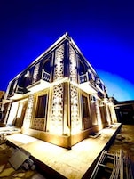 A multi-story building with intricate lattice window designs and a balcony on the upper floor.