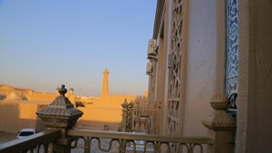 A balcony with a view of a historic building and a tower in the distance. - Turon Khiva (Khiva)