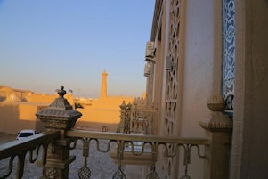 A balcony with a view of a historic building and a tower in the distance.