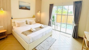 A bedroom with a large bed, a view of a balcony, and a painting on the wall. - Rabbit Villa Bangsaray (Sattahip)