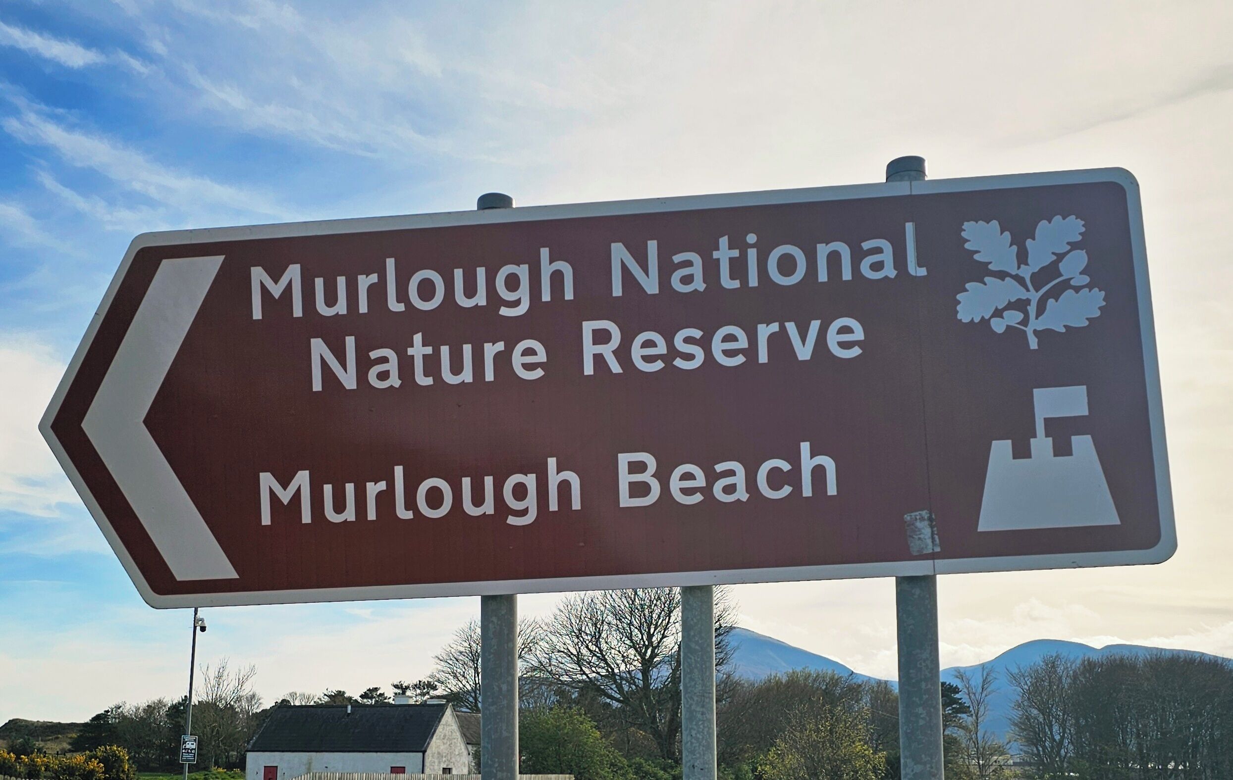 Panneau de signalisation indiquant la direction de la réserve naturelle nationale de Murlough et de la plage de Murlough.