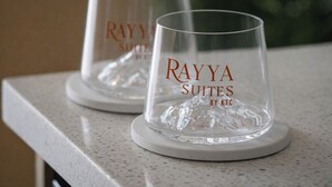 Two clear glass tumblers with "Rayya Suites by KTC" embossed on them, placed on white coasters on a countertop. - Rayya Suites, Paihia (Paihia)