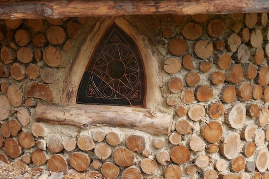 A stone wall with a decorative wooden window.