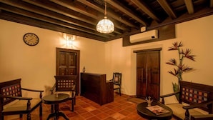 Una habitación tradicional con muebles de madera, un reloj y una araña.