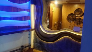 A bathroom with a modern design, featuring a curved sink and a mirror with a decorative wall. - Baan Kamala Backpacker (Kamala)