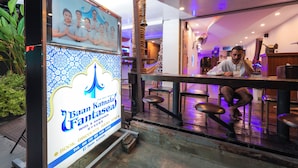 A promotional sign for Baan Kamila Fanta, a hotel with a traditional design and a bar area visible inside. - Baan Kamala Backpacker (Kamala)