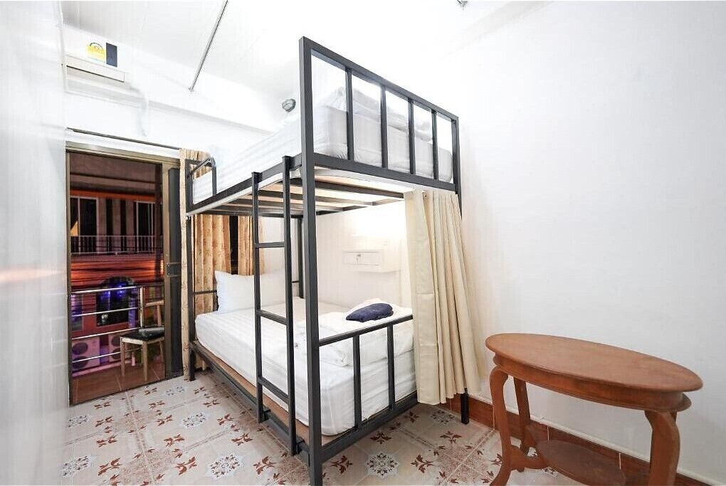 A bunk bed room with a wooden table and a small chair.