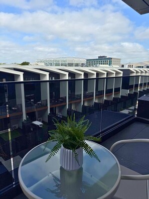 A modern building with a glass facade and a rooftop terrace with a potted plant. - Contemporary City Living on Manchester Street (Christchurch)