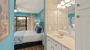 A bedroom with a bed, a nightstand, a dresser, a large mirror, and a window with curtains. - PCB Condo Near Pier Park + Pool + Pickleball Court | Beachwalk 10B by AvantStay (Panama City Beach)