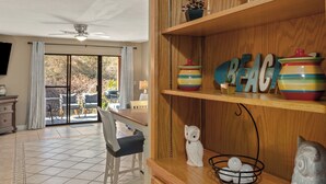 A dining area with a table, chairs, and a view through a glass door to an outdoor patio. - PCB Condo Near Pier Park + Pool + Pickleball Court | Beachwalk 10B by AvantStay (Panama City Beach)