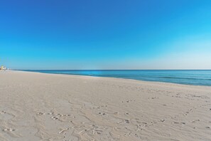 A sandy beach with footprints leading to the water. - PCB Condo Near Pier Park + Pool + Pickleball Court | Beachwalk 10B by AvantStay (Panama City Beach)