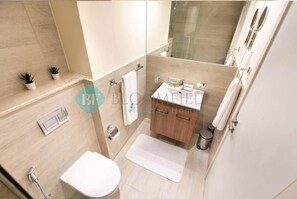 Un bagno moderno con doccia, WC, lavabo e piccolo lavandino.