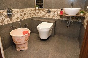 Un baño con inodoro, bidé y lavamanos.