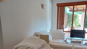 Ein Hotelzimmer mit Bett, Fernseher, Tisch mit Handtüchern und Stuhl.
