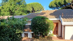 Ein Haus mit Ziegeldach, Holztür und einem kleinen Garten mit einem Weg zum Eingang.