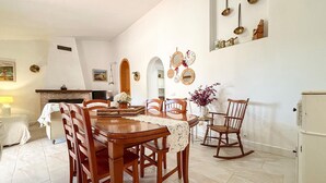 Un comedor con una mesa de madera, sillas y chimenea.