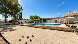 Un área de piscina con cancha de arena y un edificio al fondo.