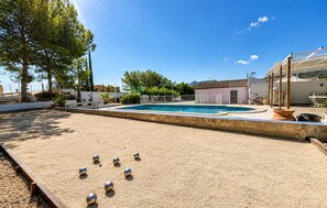 A pool area with a sand court and a building in the background. - Awesome home in Abarán (Abarán)