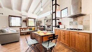 A spacious kitchen with wooden cabinets, a dining table, and a built-in stove.