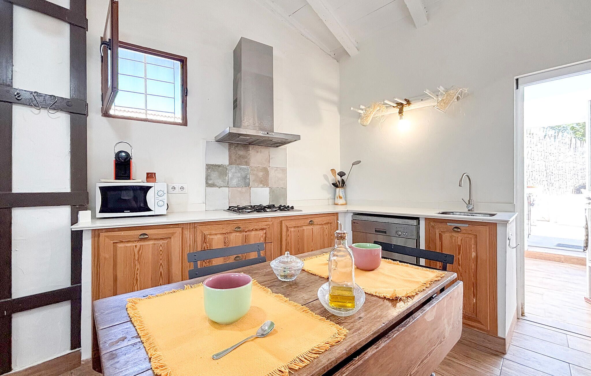 Une cuisine avec des meubles de rangement en bois, un four à micro-ondes, une cuisinière et un évier.