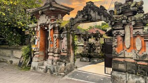 An ancient stone gate with intricate carvings, leading to a traditional building. - Putu's Paradise Ubud (Ubud)