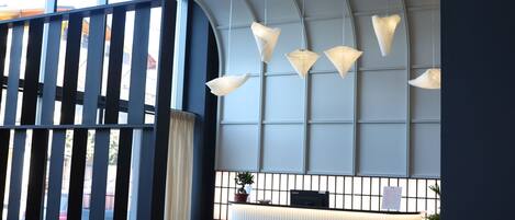 A modern reception area with a curved desk, a unique seating arrangement, and a distinctive ceiling light fixture.