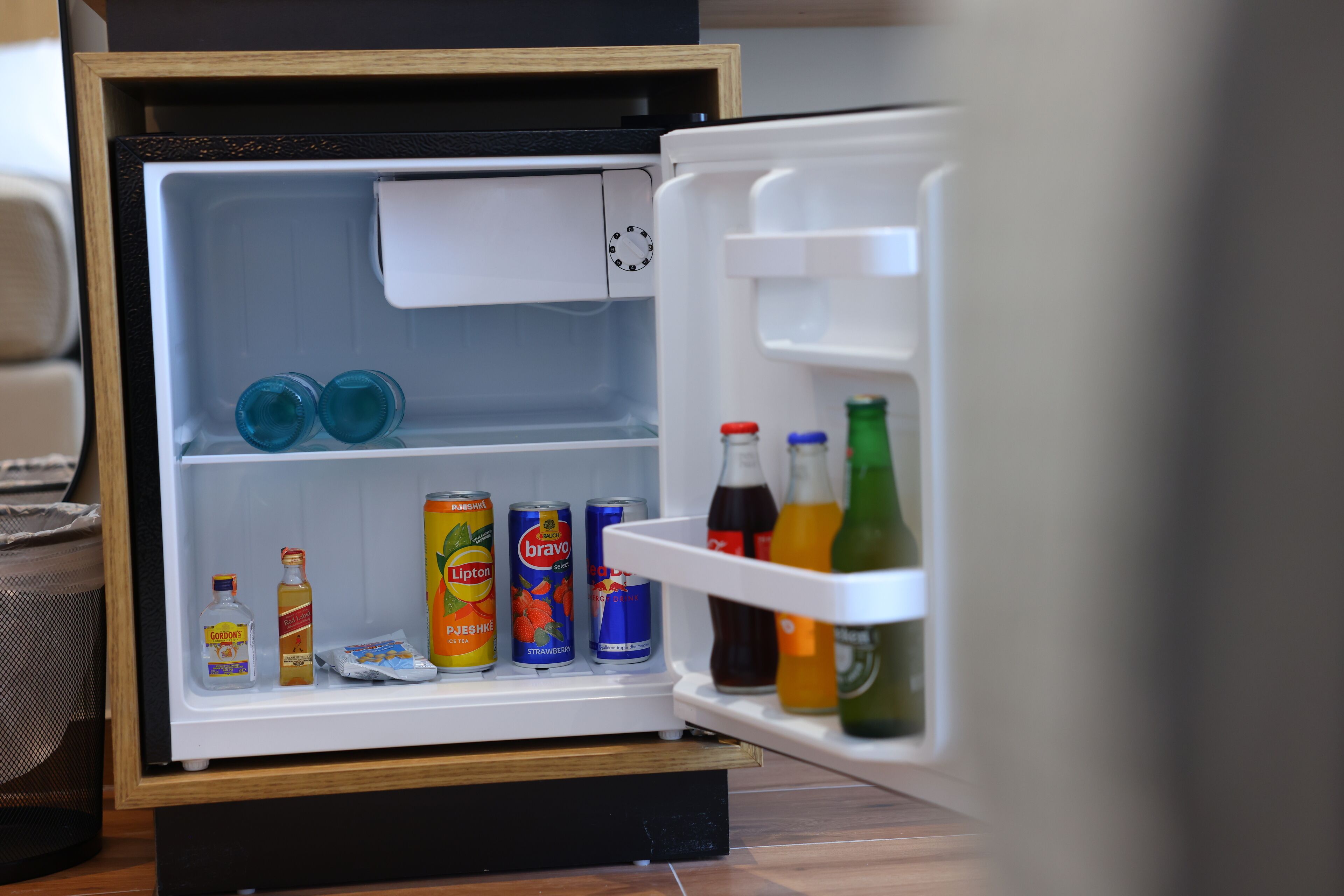 Un réfrigérateur ouvert, contenant diverses boissons et condiments.