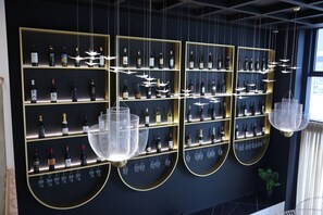 A wall of wine bottles and glasses in a modern setting. - Mece Hotel (Tirana)