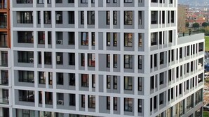 Um hotel moderno com fachada de vidro e vários andares.