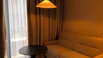 Una habitación con un sofá, una mesa redonda y una lámpara colgante.