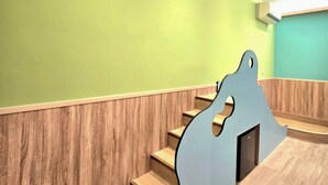 Una scala con gradini in legno e un corrimano blu che conduce a una parete color acquamarina.