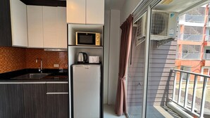 A compact kitchen with a microwave, refrigerator, and sink. - Stylish Pool-view Studio With Balcony - New Nordic VIP 3, Pratumnak (Pattaya)