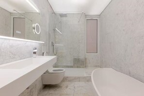 A modern bathroom with a marble floor, a white sink, a toilet, and a bathtub. - LuxuryChamps-Élysées-Air conditioning-6Voyageurs-Design&Comfort (Paris)