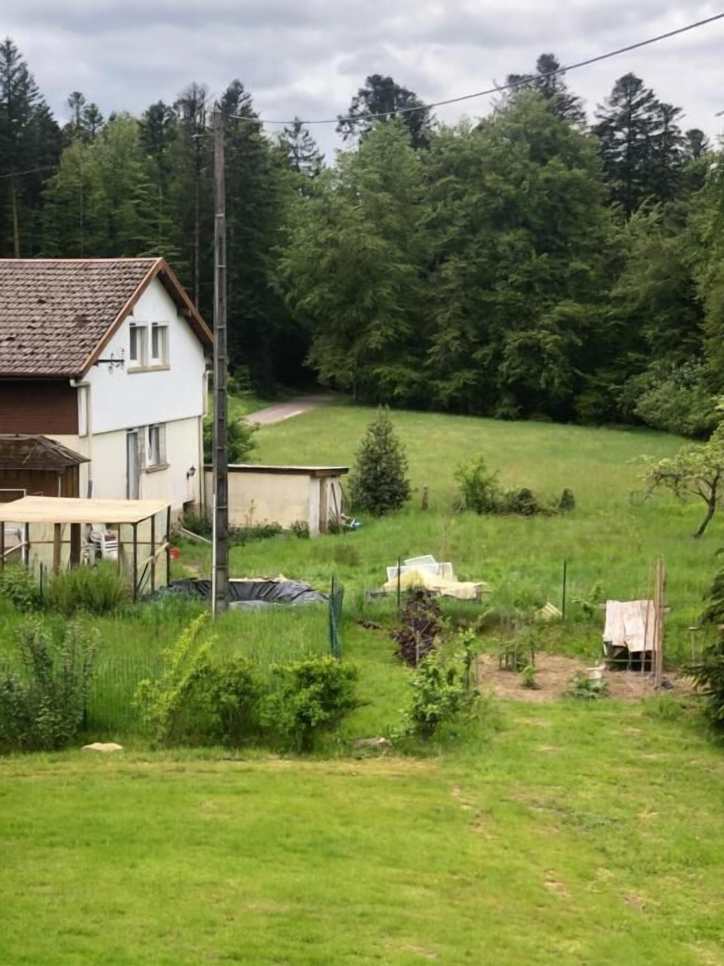 Een huis met omheinde tuin, een houten terras en een tuin.