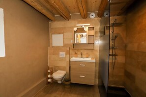 A compact bathroom with a toilet, sink, and shower.