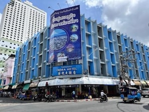 Un hotel con una fachada azul llamativa y un cartel grande que anuncia el hotel.