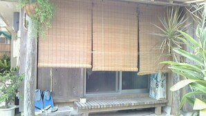 Une véranda en bois avec un banc, une porte coulissante et une plante en pot.