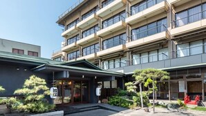 A multi-story hotel with a modern architectural design, featuring balconies and large windows. - Sumie Chita (Minamichita)