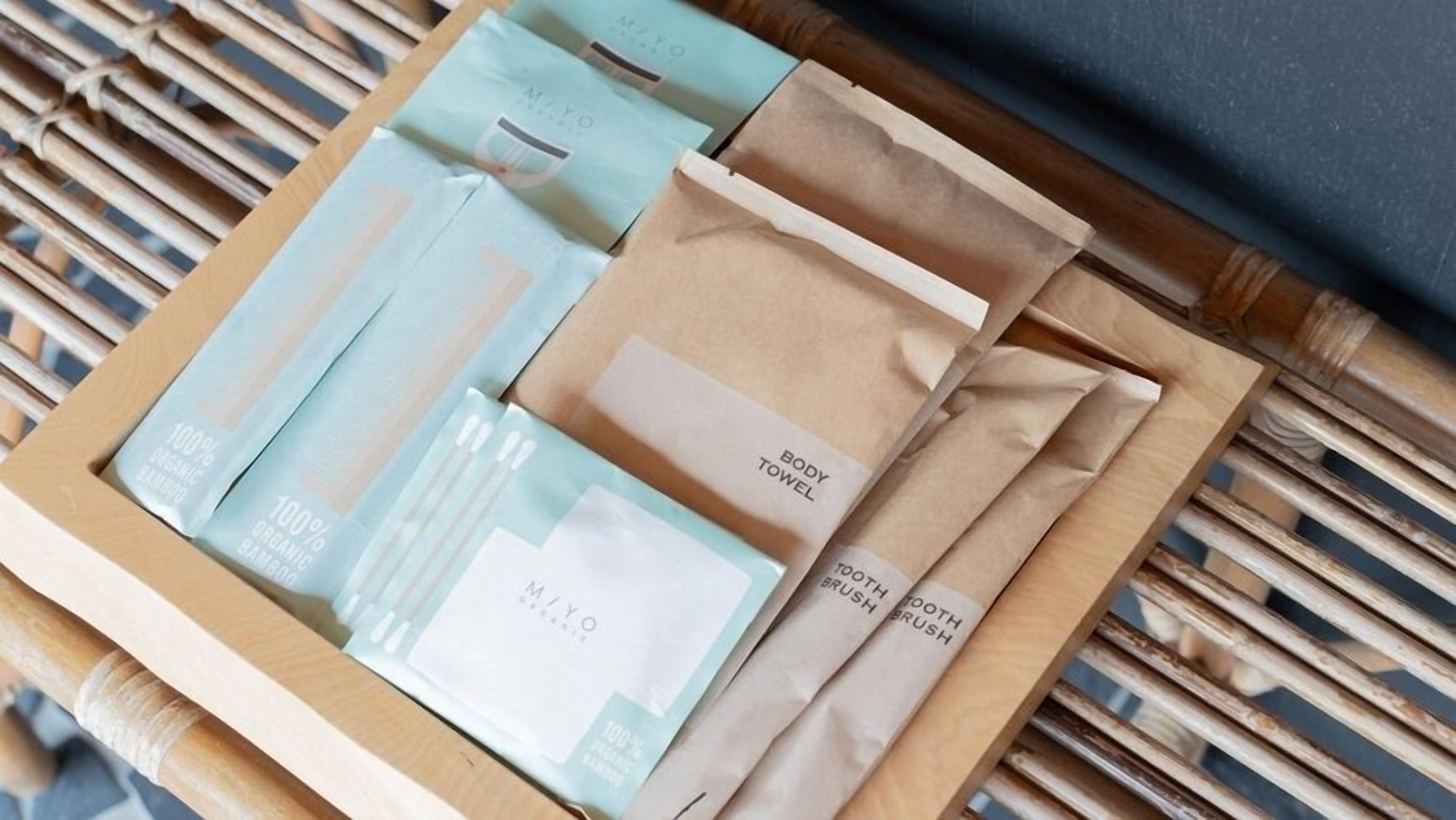 A wooden tray with various items including bamboo products and a body towel.