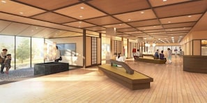 Un hall d’entrée spacieux avec un plafond haut, un plancher en bois et un espace salon central.